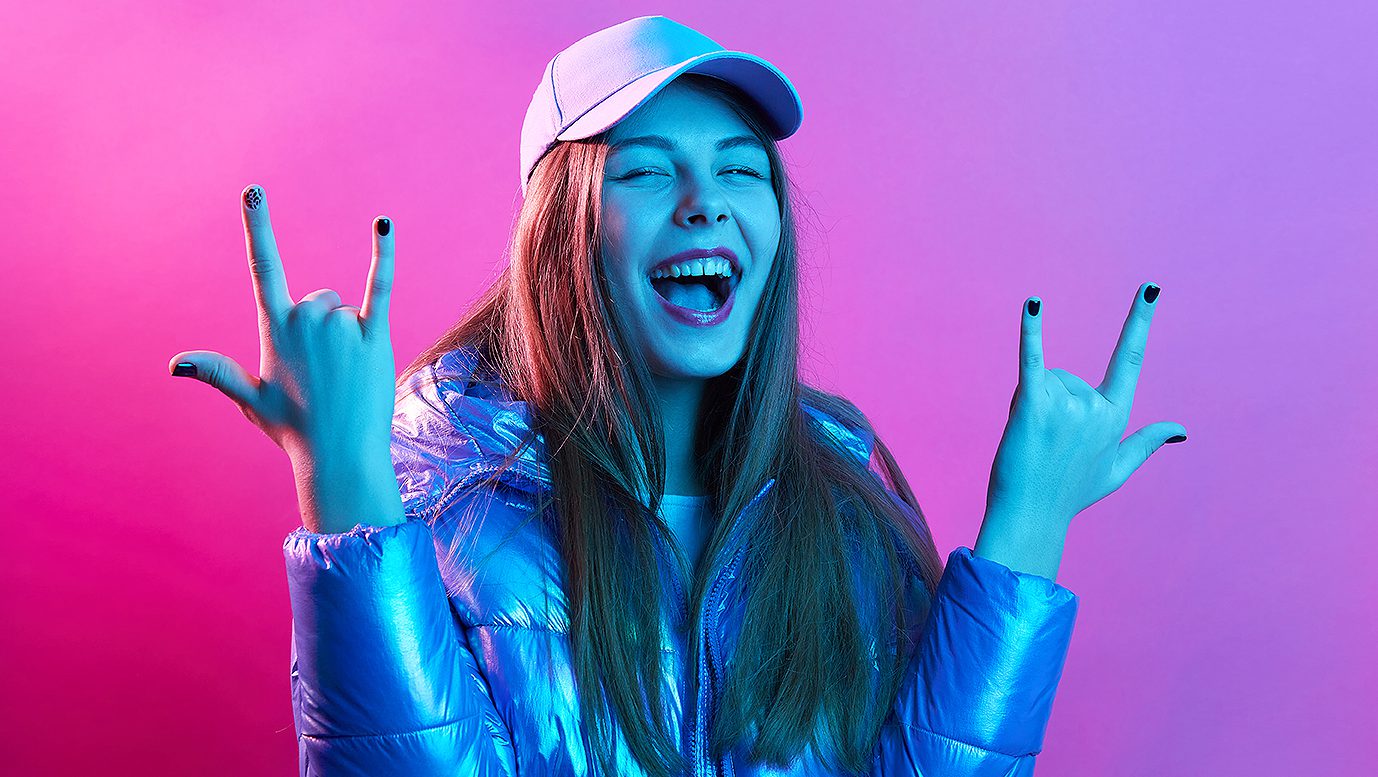 Happy excited woman showing rock gesture with fingers, visiting